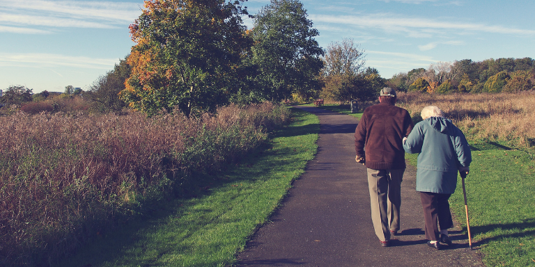 Un vieux couple se promène le long d'un chemin